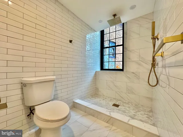 a bathroom with a toilet and a shower