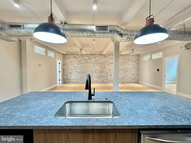 a kitchen with a sink a counter space and a refrigerator