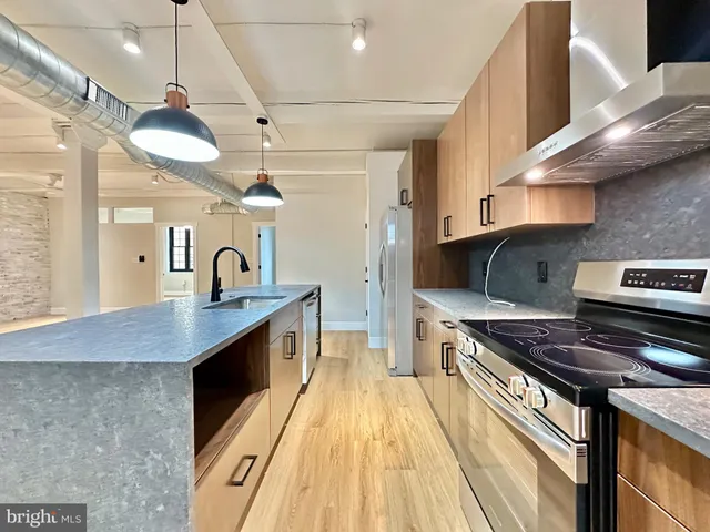 a kitchen with stainless steel appliances granite countertop a stove a sink and a refrigerator