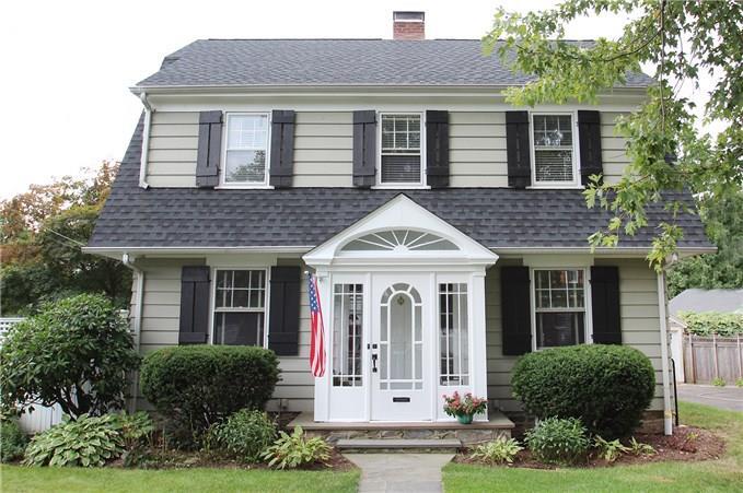 a front view of a house with a yard and plants