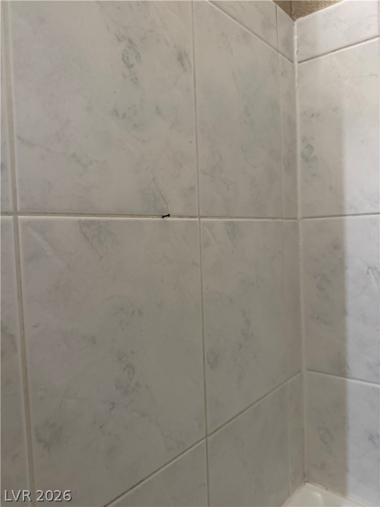 135 Primero Way Henderson, NV 89074 - Photo 14 of 15 Clean, neutral-toned ceramic tile walls offer a timeless aesthetic.