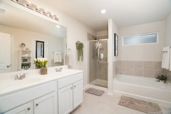 a bathroom with a bathtub shower sink vanity and toilet