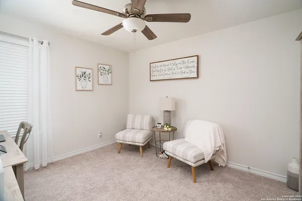 a living room with furniture and a ceiling fan