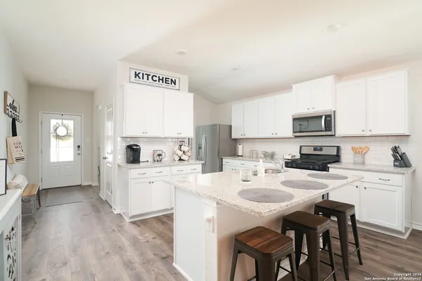 a kitchen with white cabinets and white appliances