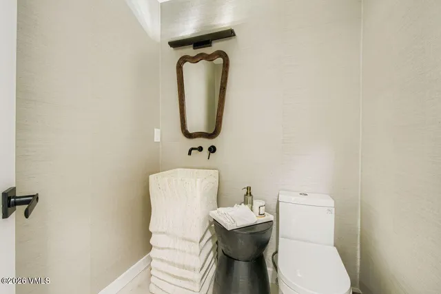 a white toilet sitting next to a bathroom sink