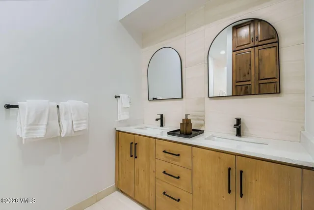 a bathroom with a granite countertop toilet sink and mirror
