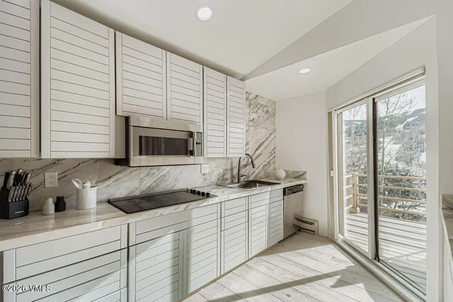 a kitchen with stainless steel appliances a sink stove and cabinets