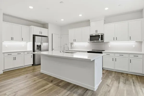 a kitchen with white cabinets and appliances