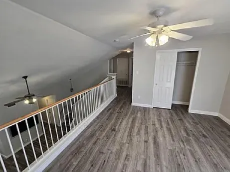 a view of a hallway with wooden floor and chandelier