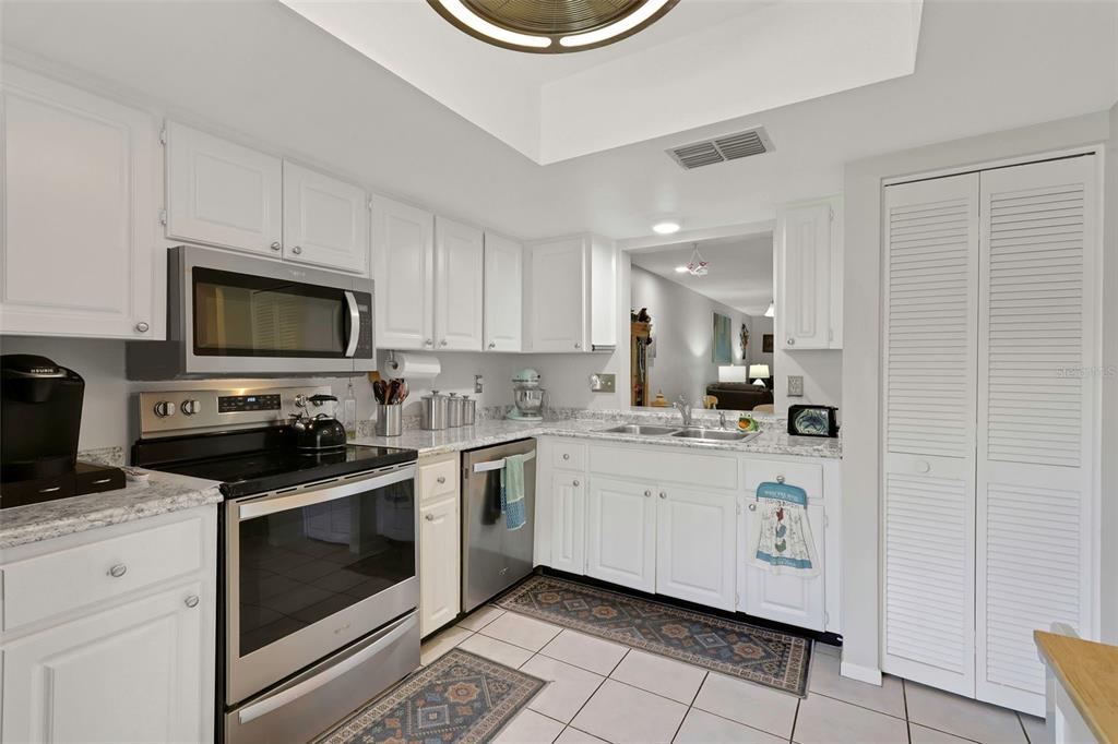 1011 Dunrobin Drive, Unit B Palm Harbor, FL 34684 - Photo 15 of 37 a kitchen with a sink a stove and cabinets