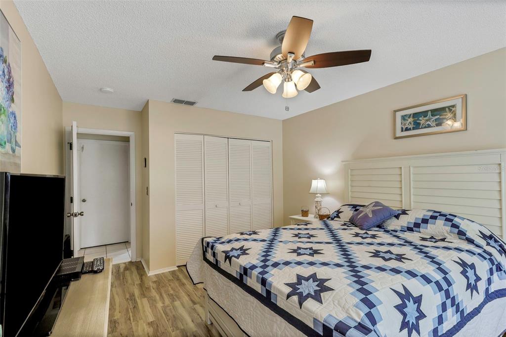1011 Dunrobin Drive, Unit B Palm Harbor, FL 34684 - Photo 21 of 37 a bedroom with bed and a chandelier