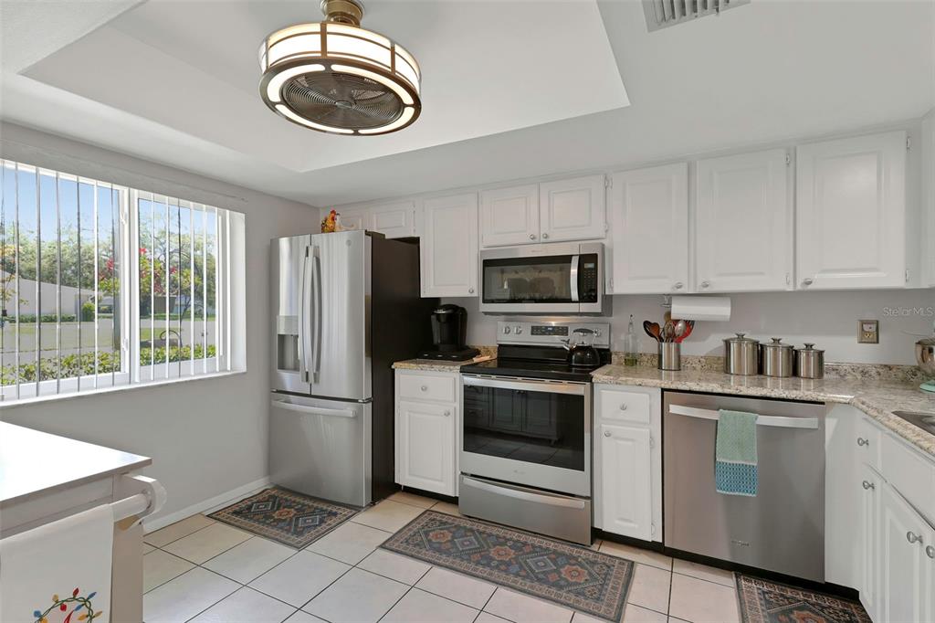 1011 Dunrobin Drive, Unit B Palm Harbor, FL 34684 - Photo 4 of 37 a kitchen with stainless steel appliances granite countertop a stove a sink and a microwave