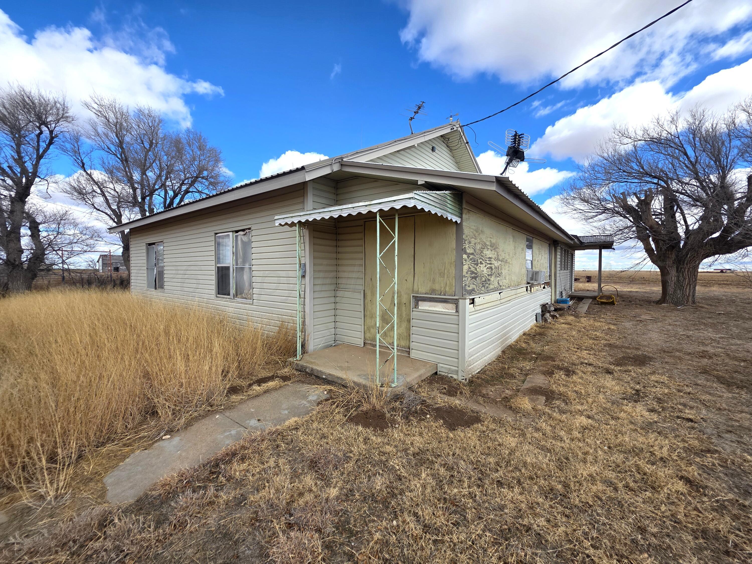 330 Major Reed Road Pampa, TX 79065 - Photo 2 of 19 a house with white wall of the house next to a yard