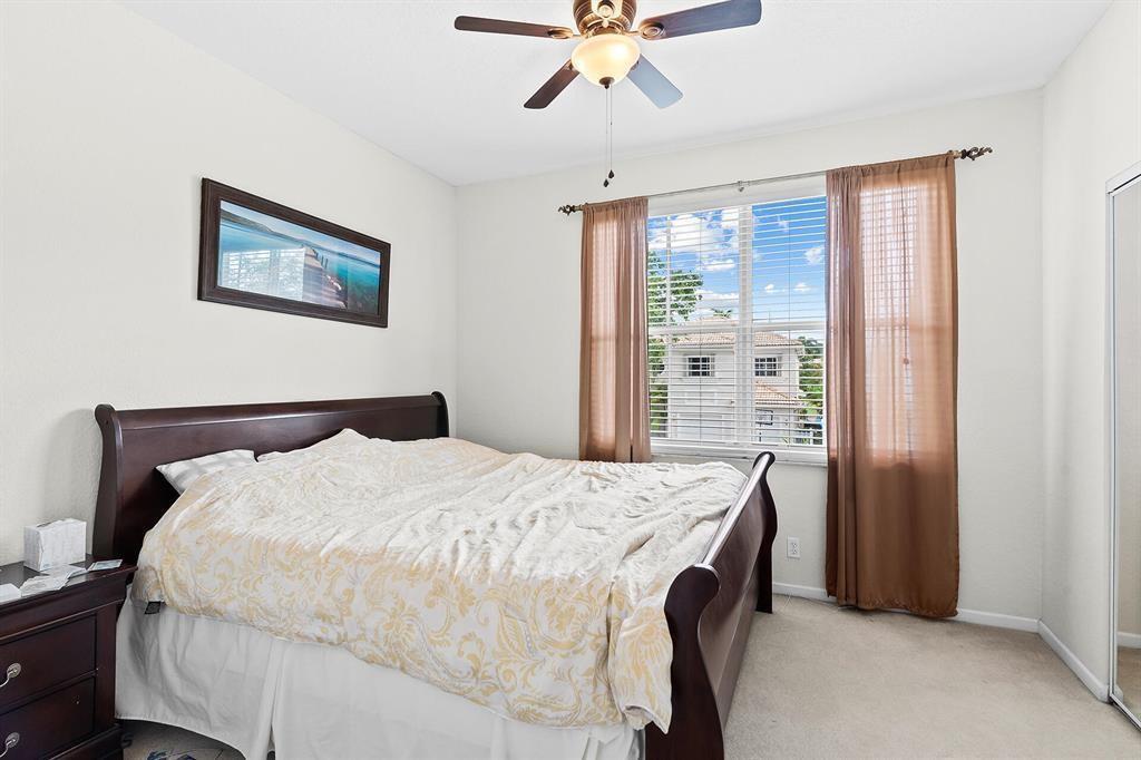 9728 Vineyard Court Boca Raton, FL 33428 - Photo 14 of 17 a bedroom with a bed and a chandelier