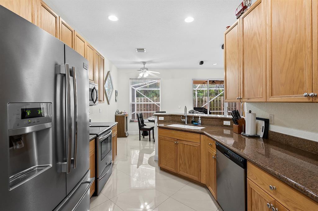 9728 Vineyard Court Boca Raton, FL 33428 - Photo 7 of 17 a kitchen with a sink stainless steel appliances a counter top space and cabinets