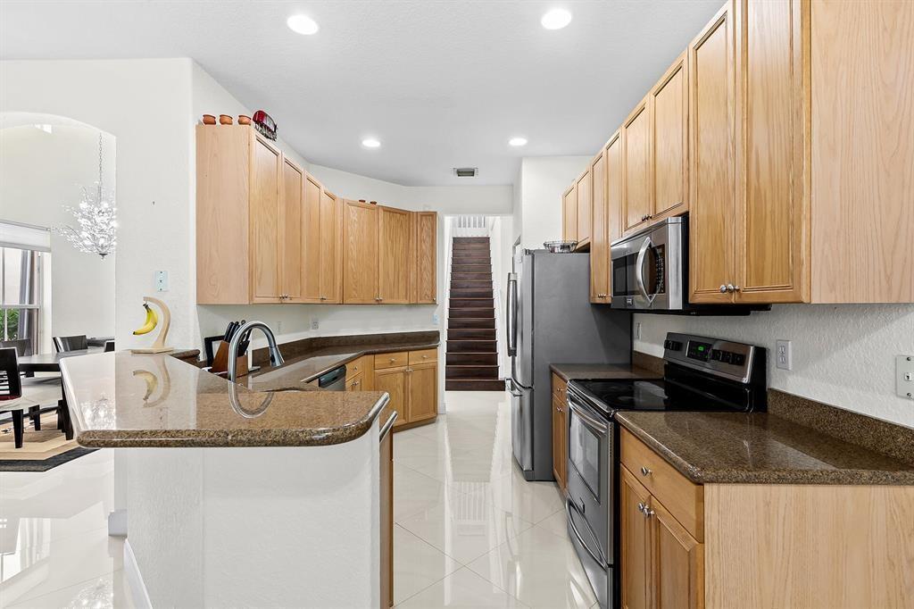 9728 Vineyard Court Boca Raton, FL 33428 - Photo 8 of 17 a kitchen with stainless steel appliances granite countertop a sink a stove and a refrigerator