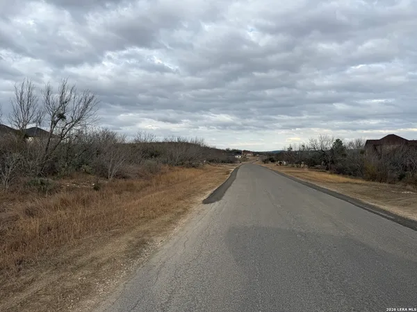 a view of a road with wooden fence