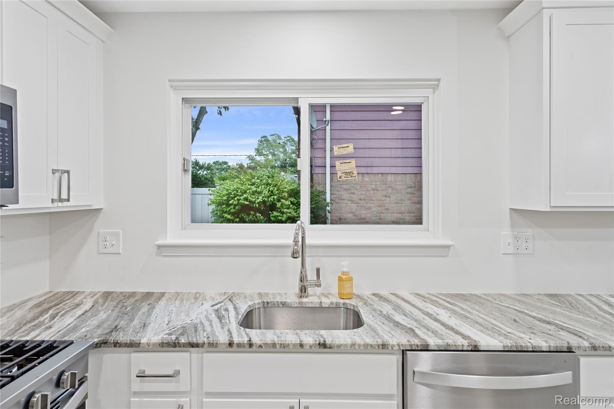 8240 Hampton Road Grosse Ile, MI 48138 - Photo 8 of 33 White cabinetry, stainless steel sink, contemporary faucet, stone countertop, and a window