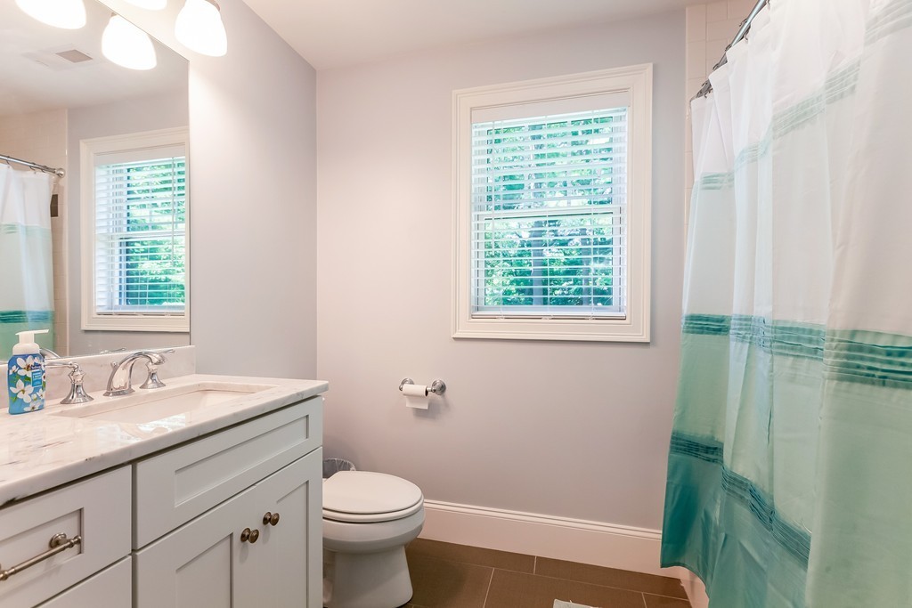 65 Leland Road Boston, MA 02467 - Photo 24 of 30 a bathroom with a sink a toilet and a window