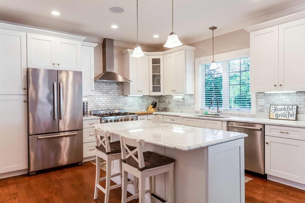 65 Leland Road Boston, MA 02467 - Photo 8 of 30 a kitchen with stainless steel appliances granite countertop a sink a stove a refrigerator and island with wooden floor