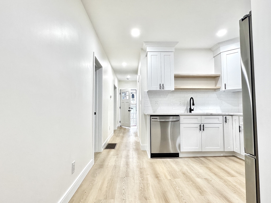 78 Orchard Street, Unit 78 Medford, MA 02155 - Photo 2 of 11 a kitchen with stainless steel appliances granite countertop a sink and cabinets