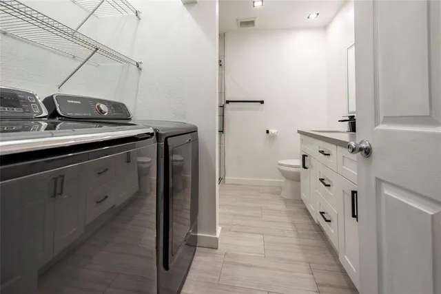 a spacious bathroom with double vanity and mirrors