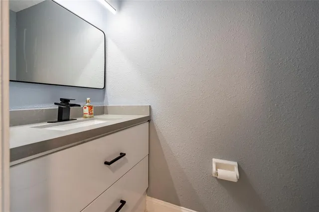a bathroom with a sink a mirror and vanity