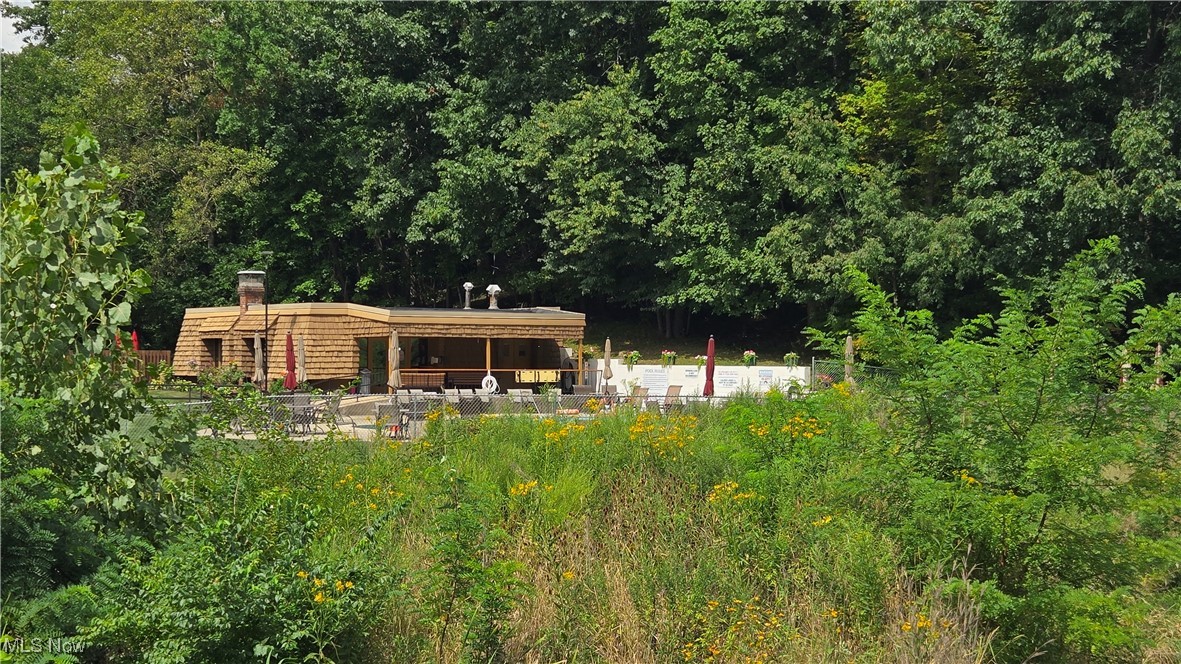 3068 Kent Road, Unit 210C Stow, OH 44224 - Photo 4 of 14 Back of pool house with a view of trees, a patio,