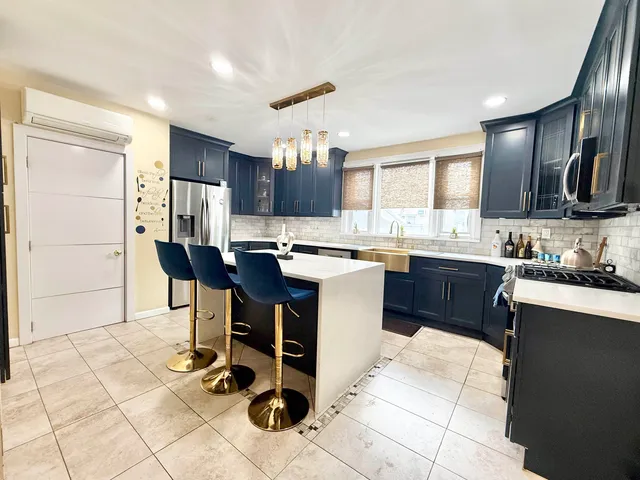 a kitchen with a sink a stove a refrigerator and wooden cabinets