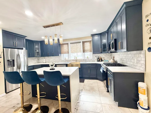 a kitchen with a refrigerator a stove top oven a sink dishwasher and wooden cabinets