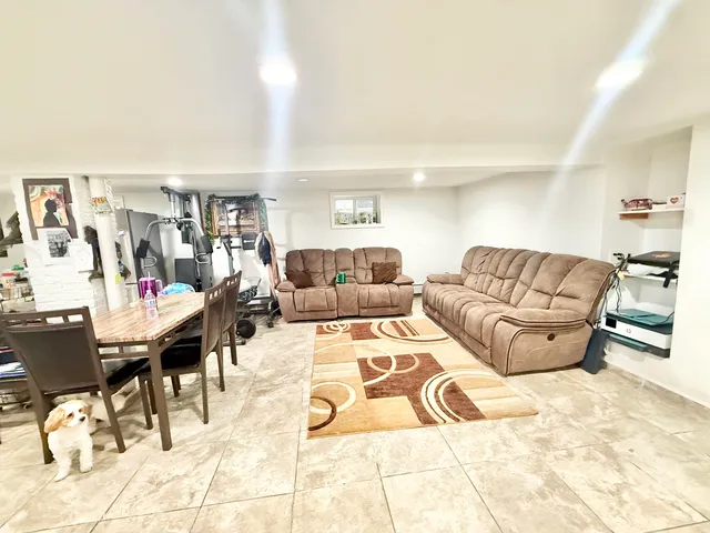 a living room with furniture kitchen view and a window