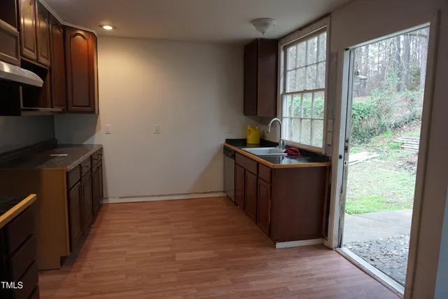 a kitchen with granite countertop a stove a sink and a refrigerator