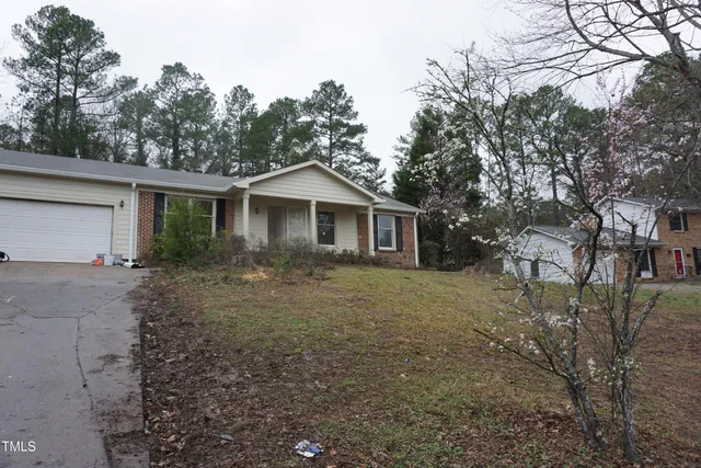 a view of a yard in front of a house with large trees