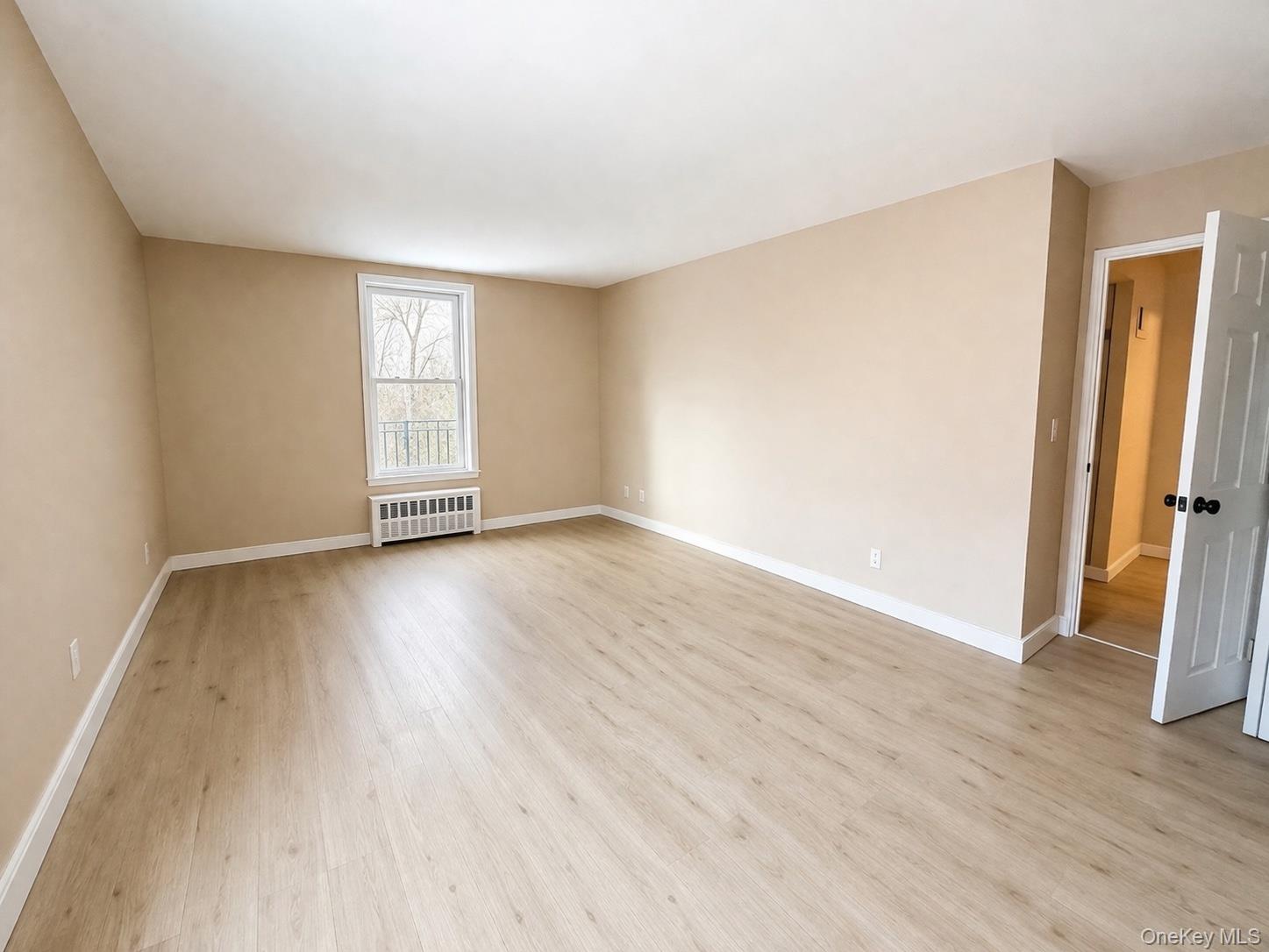 245 Rumsey Road, Unit 3E Yonkers, NY 10701 - Photo 13 of 24 an empty room with wooden floor and a window