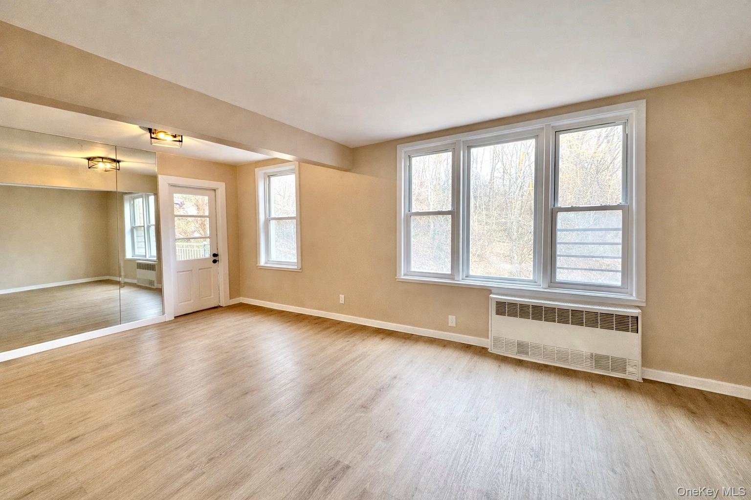 245 Rumsey Road, Unit 3E Yonkers, NY 10701 - Photo 3 of 24 an empty room with wooden floor and windows
