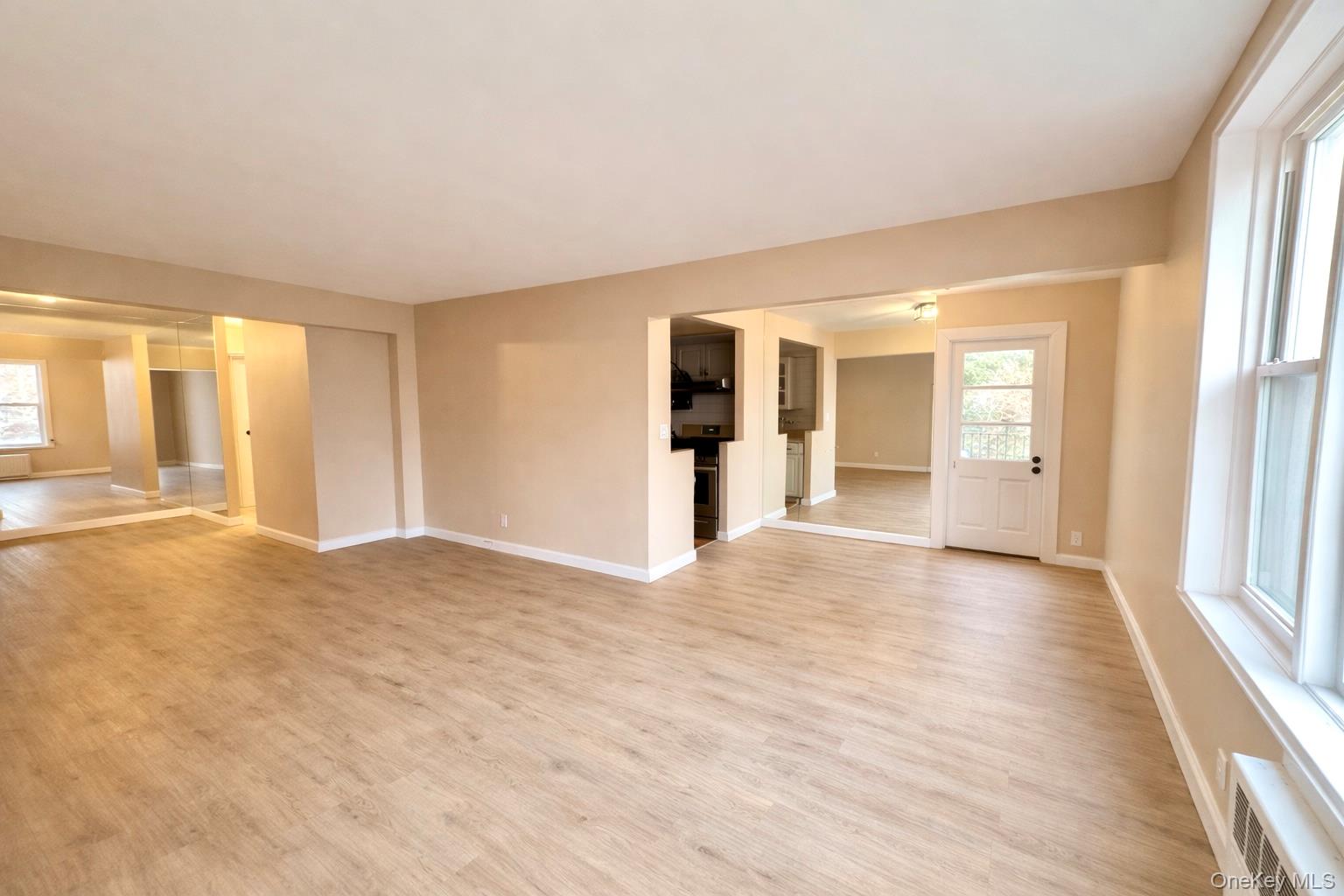 245 Rumsey Road, Unit 3E Yonkers, NY 10701 - Photo 4 of 24 a view of an empty room with window and a kitchen