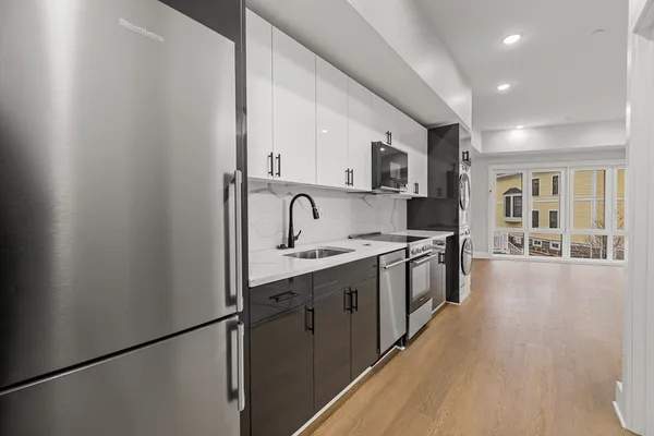 a kitchen with stainless steel appliances granite countertop a sink stove and refrigerator