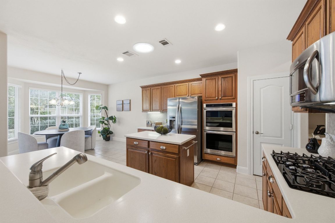 512 Armstrong Drive Georgetown, TX 78633 - Photo 17 of 40 a kitchen with stainless steel appliances kitchen island granite countertop a stove and cabinets