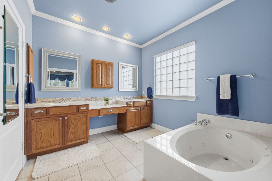 512 Armstrong Drive Georgetown, TX 78633 - Photo 27 of 40 a bathroom with a granite countertop bathtub sink and mirror