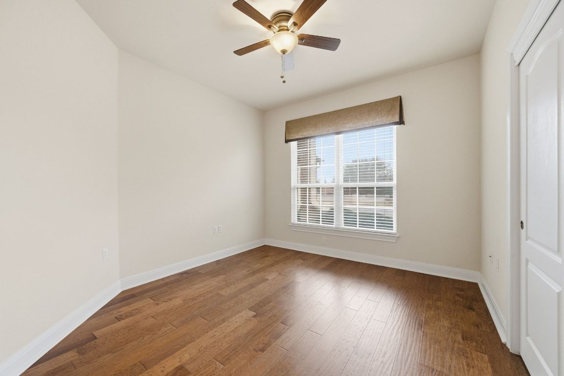 512 Armstrong Drive Georgetown, TX 78633 - Photo 29 of 40 an empty room with wooden floor chandelier fan and windows