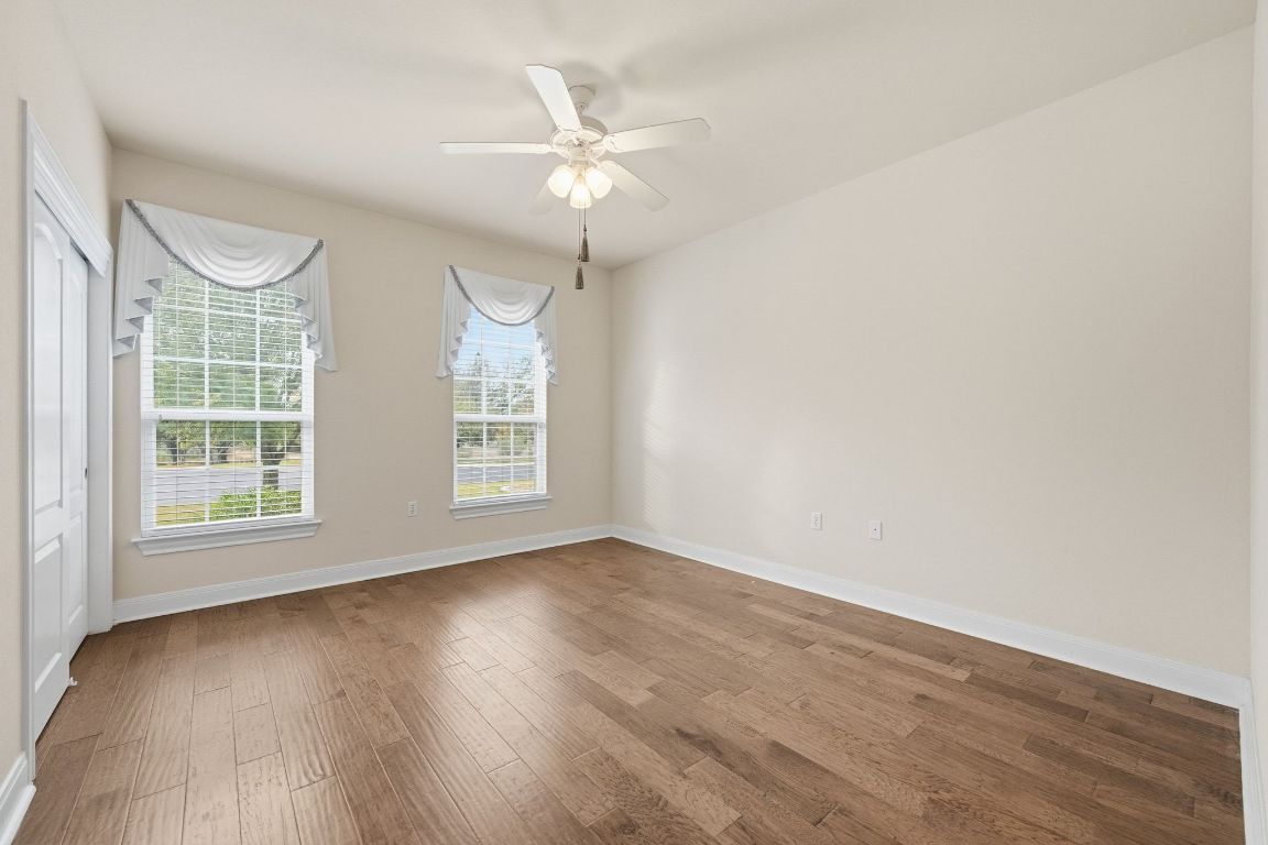 512 Armstrong Drive Georgetown, TX 78633 - Photo 30 of 40 an empty room with wooden floor fan and windows