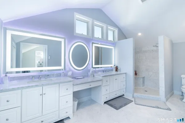 a bathroom with a granite countertop double vanity sink mirror bathtub and shower