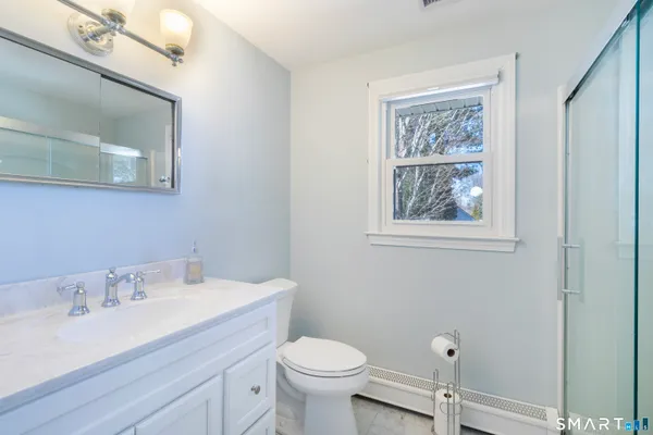 a bathroom with a toilet a sink and mirror