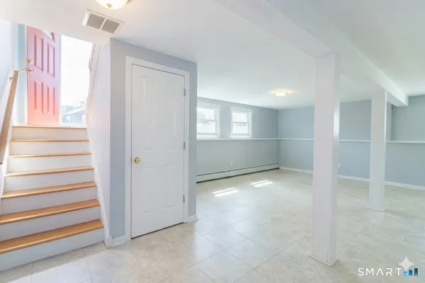 a view of an empty room with stairs and ventilation
