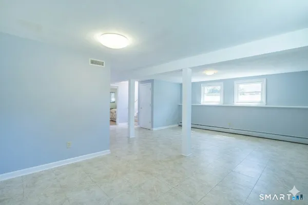 an empty room with windows and bathroom