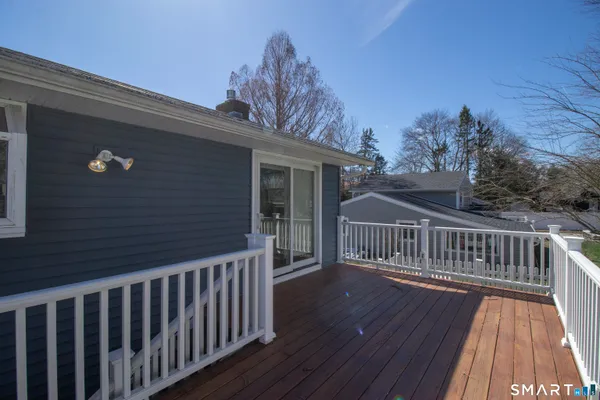 a view of deck with wooden floor and fence with a floor to ceiling window
