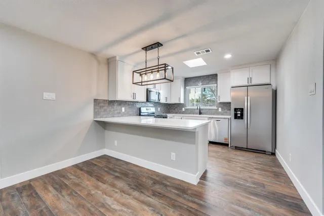 a kitchen with granite countertop a refrigerator and a sink