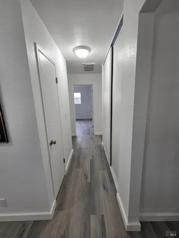 a view of a hallway with wooden floor
