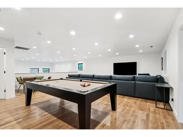 a living room with stainless steel appliances furniture and a flat screen tv