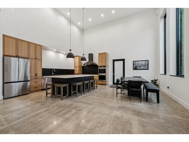 a living room with furniture a dining table and a refrigerator